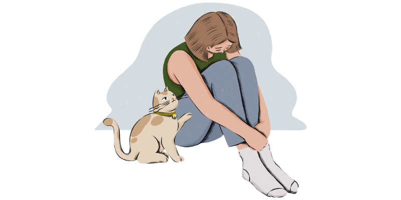 A person with shoulder length blonde is hanging their head over their knees. A gently smiling cat touches them softly.
